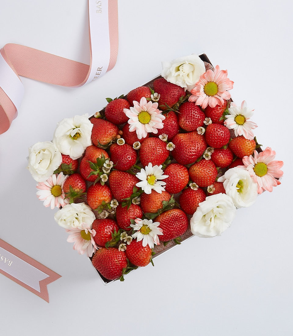 Fresh strawberries with white and pink flowers in elegant gift box