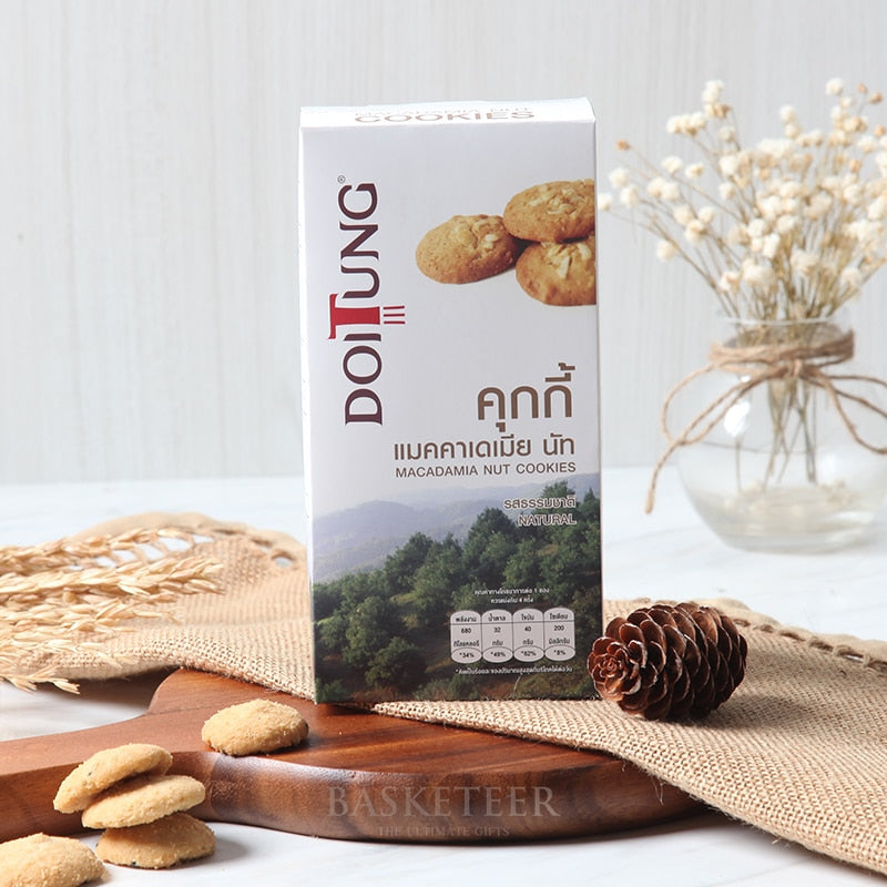 DoiTung macadamia nut cookies in white gift box with forest landscape design, scattered on wooden board with dried flowers