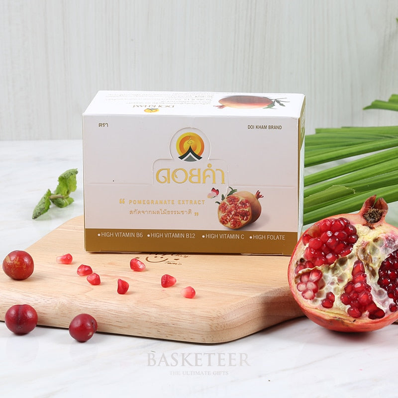 Pomegranate extract wellness box with red arils and vitamin-rich supplement package on wooden board