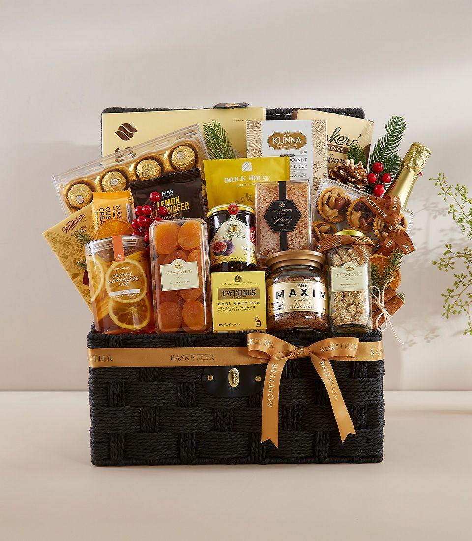 Black woven luxury gift hamper with gold ribbon, filled with gourmet chocolates, jams, tea, coffee, sparkling wine, and