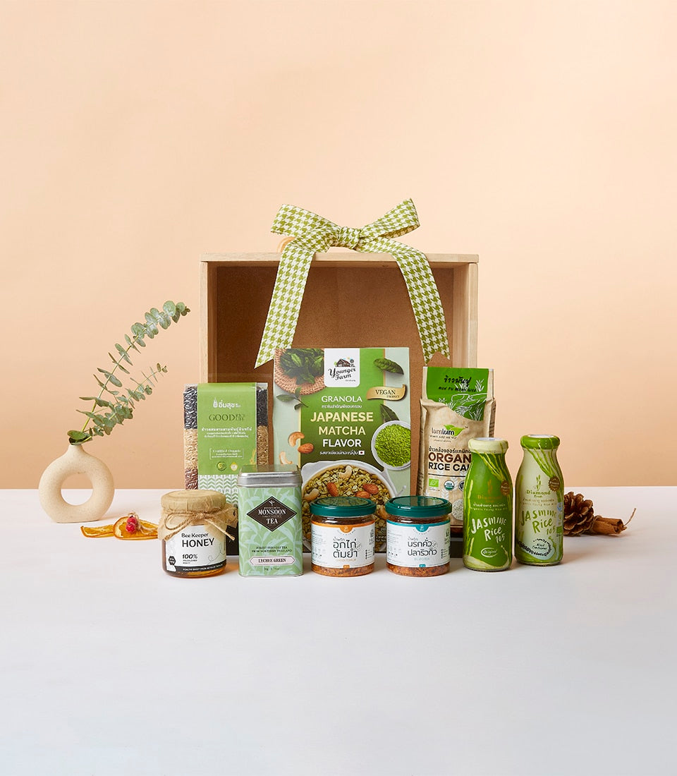 Wooden gift box with green checkered ribbon filled with matcha granola, organic grains, honey, tea, and jasmine rice