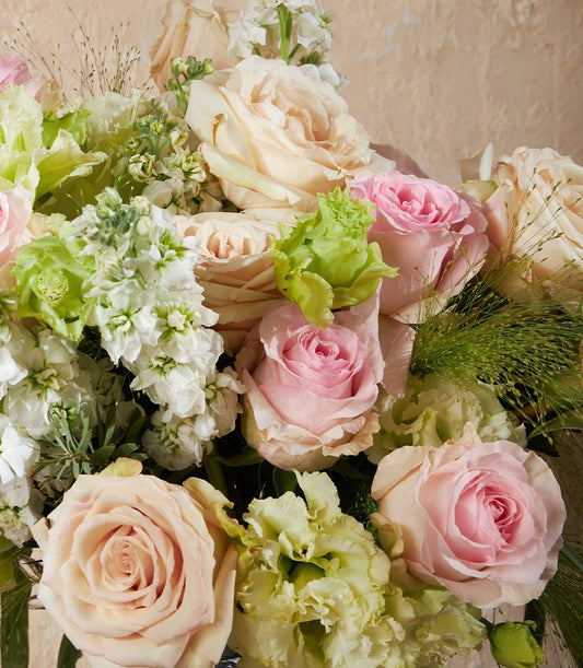 Blush and cream rose vase arrangement with soft pink blooms and green foliage for elegant gifting