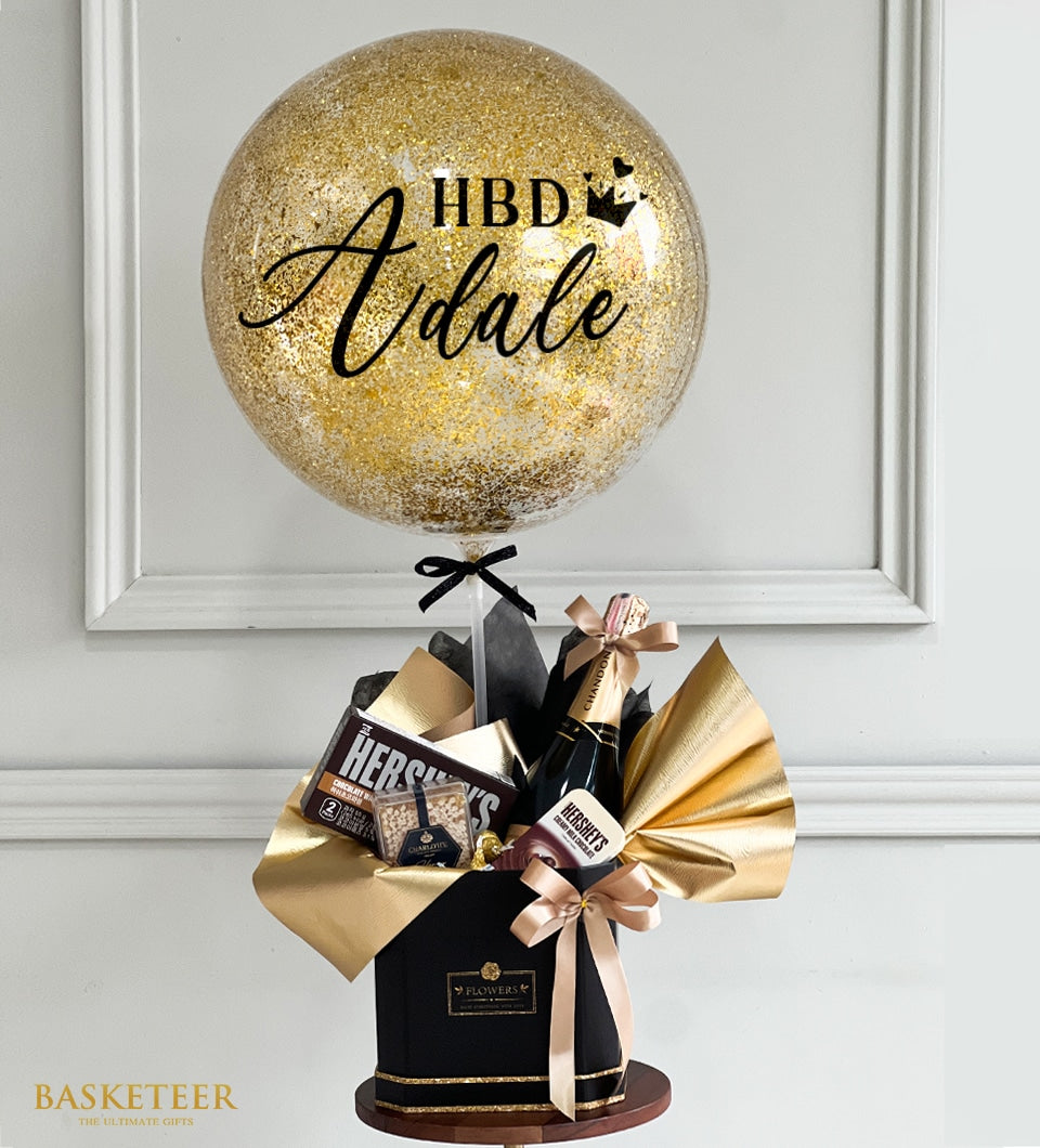 Golden glitter balloon with personalised message paired with luxury gift box containing Chandon sparkling wine, Hershey's