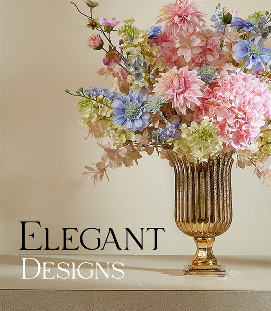 Emerald Morning Renewal artificial flowers in pink dahlias, hydrangeas, and blue-yellow blossoms arranged in gold pedestal