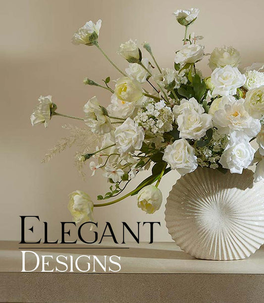 White and cream artificial flower arrangement in ribbed ceramic vase with roses and ranunculus