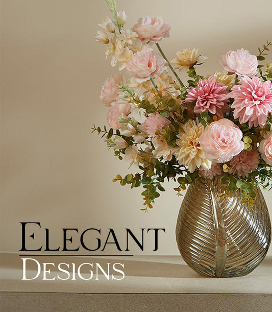 Lush artificial flower arrangement in amber glass vase with pink, peach and cream blooms