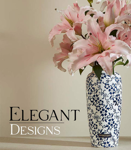 Pink lily artificial flowers in white ceramic vase with blue vine pattern