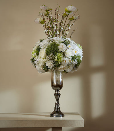 Tall bronze and smoky glass vase with white and blush artificial flowers, spherical arrangement with calla lily stems