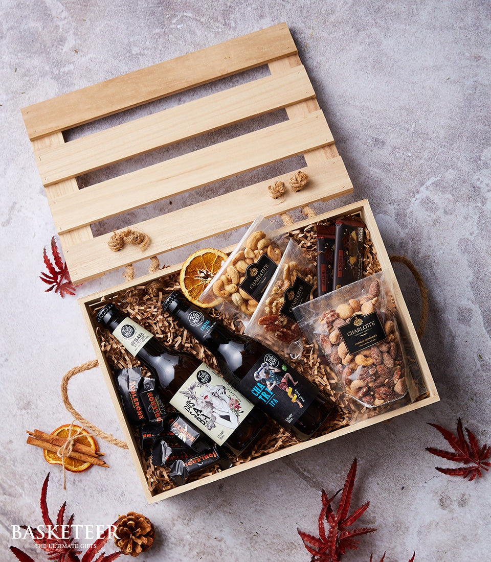 Wooden crate gift hamper with Thai craft beers, artisan chocolate bars, roasted nuts, and dried fruit