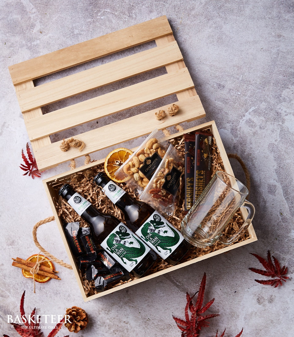 Premium beer and treats gift box with craft Chalawan beers, chocolates, nuts, and festive natural accents in wooden crate
