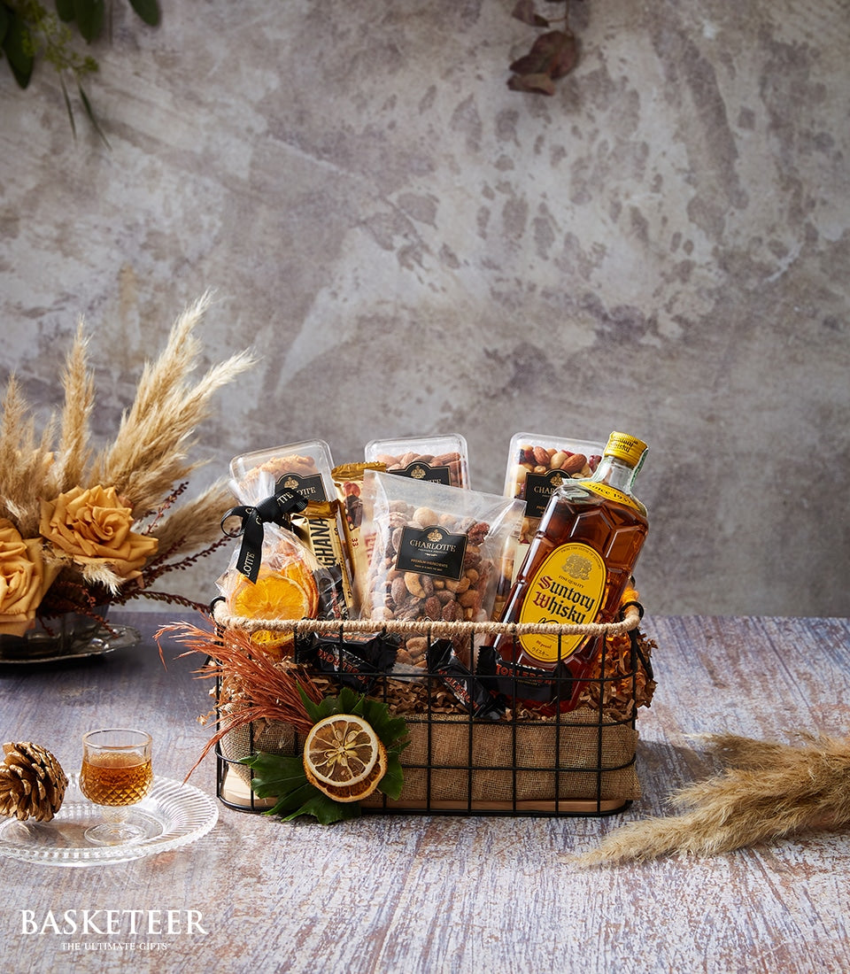 Premium Suntory whisky gift hamper with artisan nuts, dried fruits, and chocolate in dark wire basket
