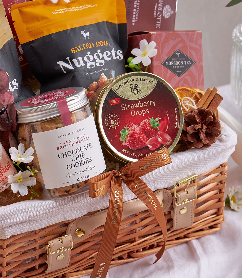 Woven wicker gourmet gift basket with salted egg nuggets, British chocolate chip cookies, strawberry candies, and Monsoon