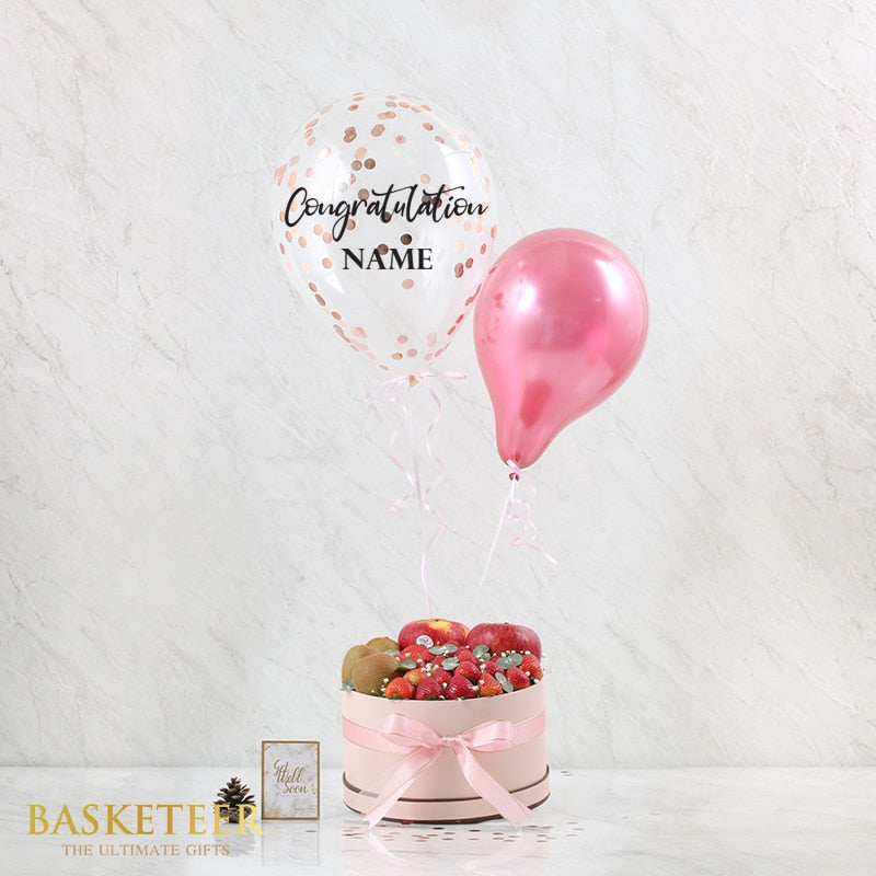 Fresh fruit gift box with congratulations balloons in rose gold and pink