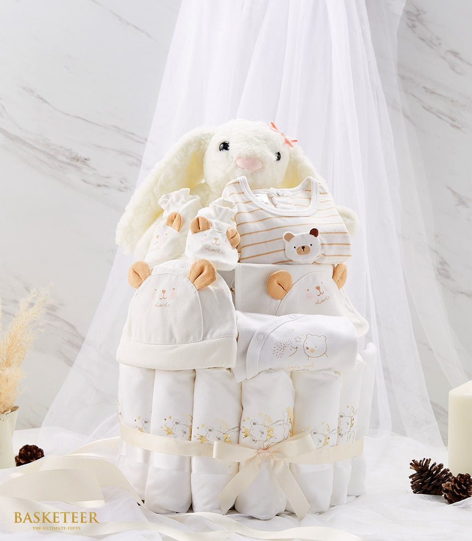 Newborn baby diaper cake with rolled white blankets, plush bunny, and bear-print clothing set