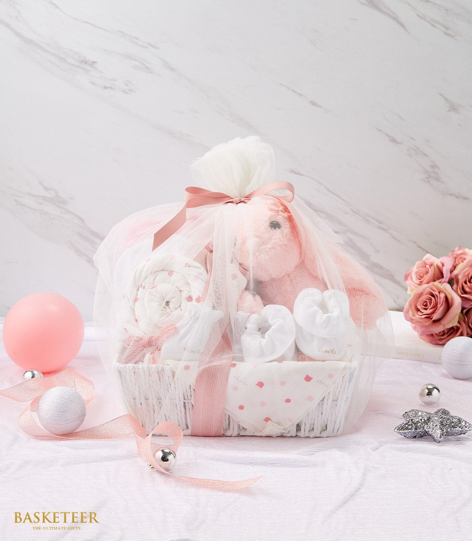 Tender Newborn Baby Love Gift Ensemble with pink bunny, booties, and polka-dot blanket in white woven basket