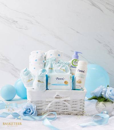 Newborn baby gift basket with blue and white essentials, blankets, booties, and lotions for new parents