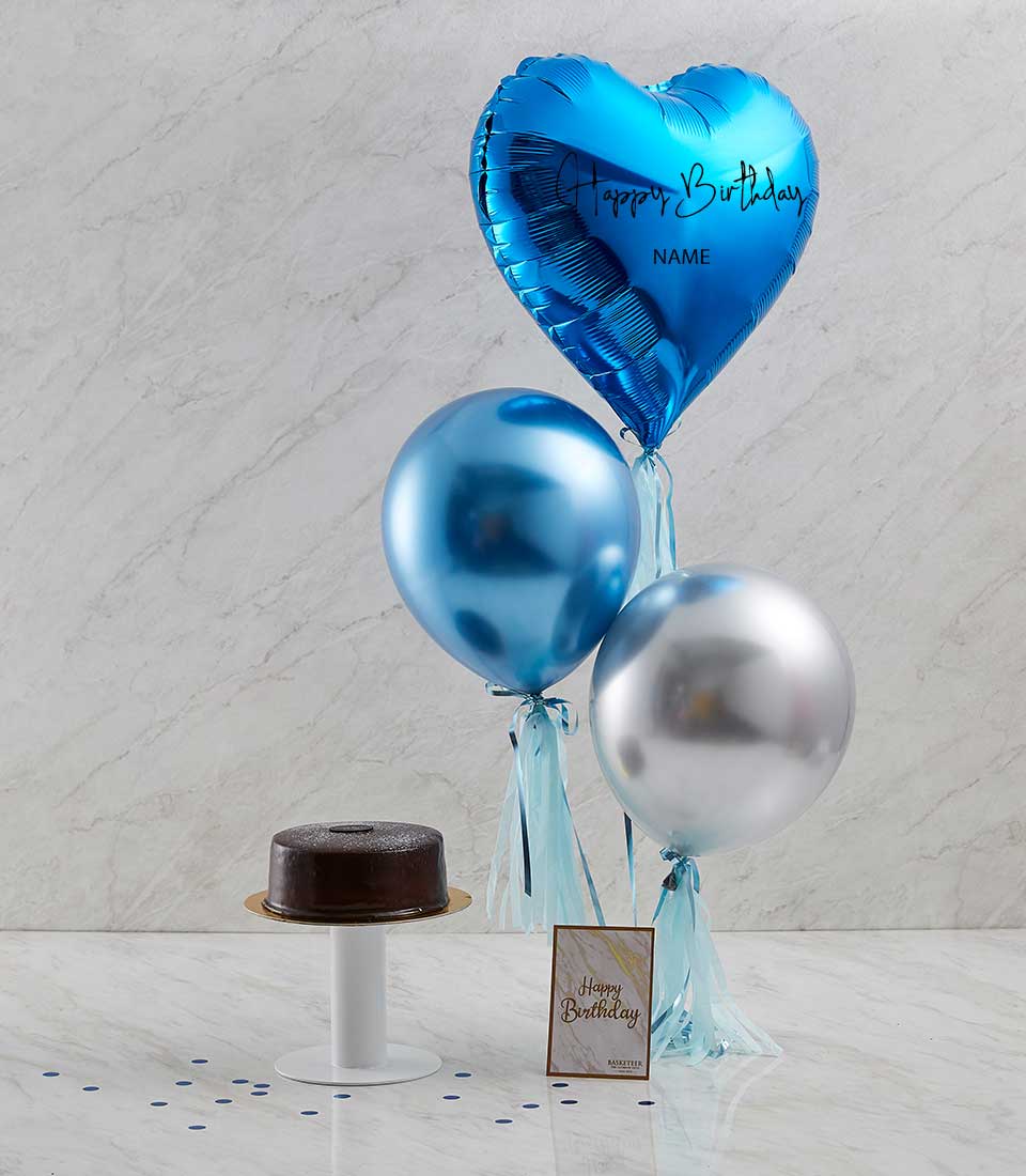 Blue heart balloon birthday gift set with chocolate cake and metallic balloons on marble surface