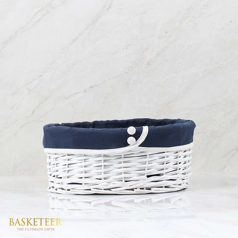 White woven rattan gift basket from Basketeer, lined with elegant navy blue fabric for a premium hamper delivery Thailand.