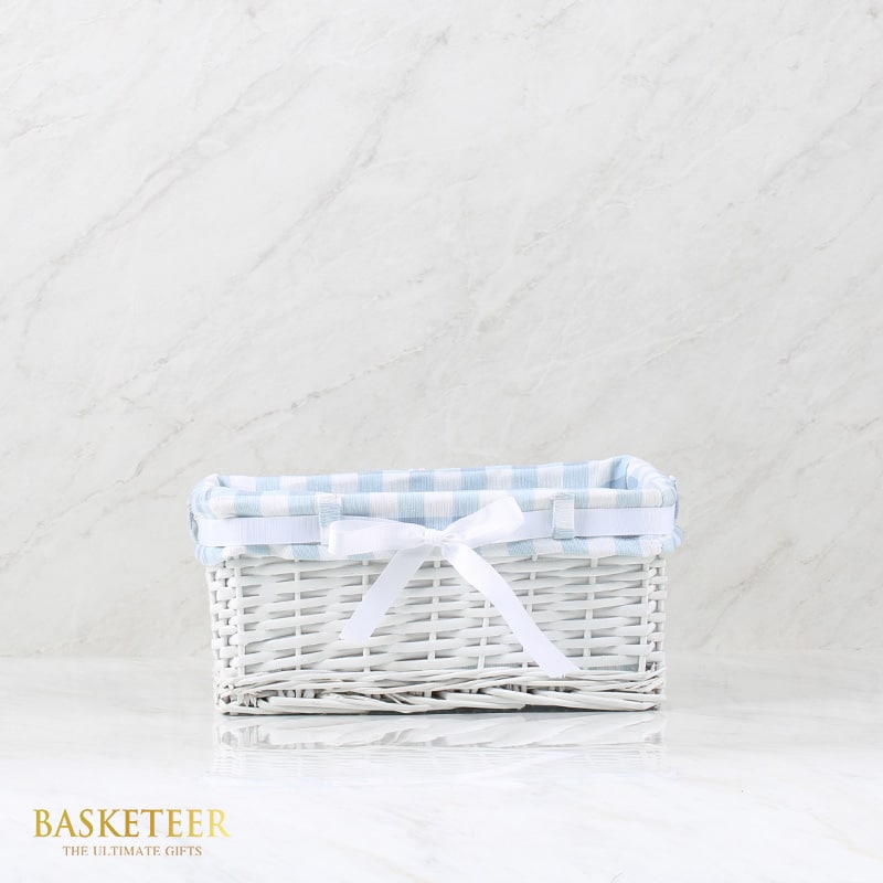 White wicker basket with light blue gingham fabric liner and satin bow