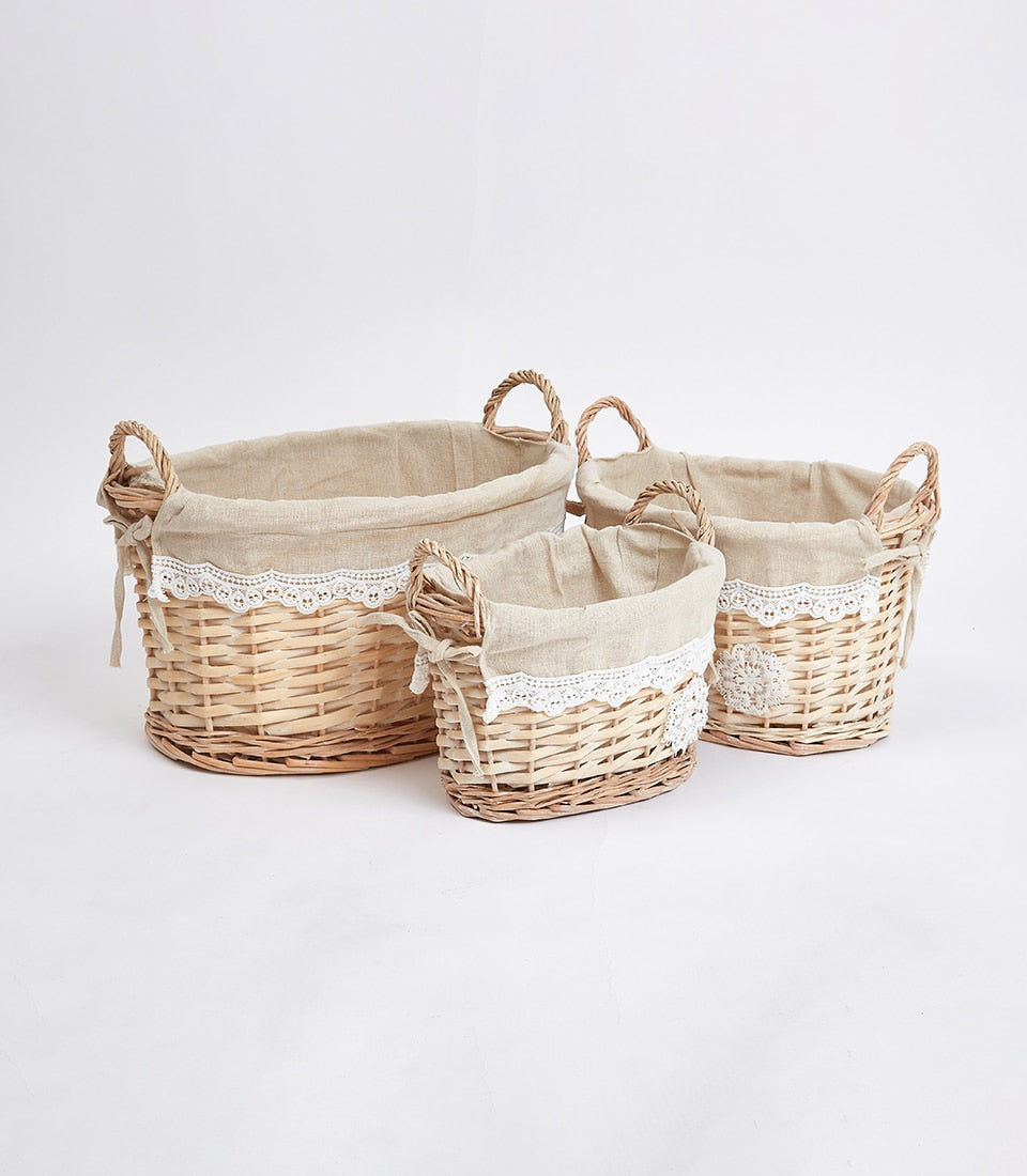 Nested oval wicker baskets with linen liners and lace trim, ideal for curated gift hampers