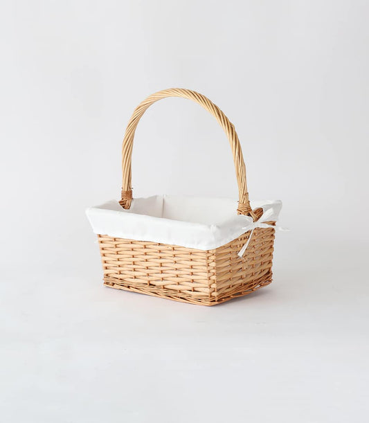Light brown wicker basket with white fabric liner and ribbon bow, ready for custom gifting