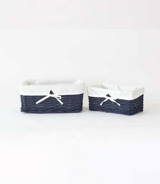 Navy blue rattan storage baskets with white fabric liners and ribbon bows