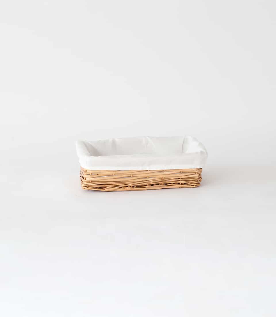 Light brown wicker basket with white cloth lining, natural reed weave for luxury gifting