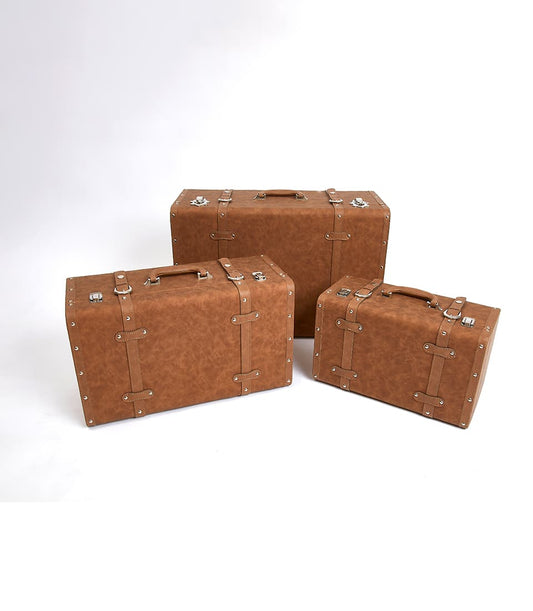 Vintage leather suitcase set in distressed tan with silver buckles and rivets, perfect for luxury gift giving