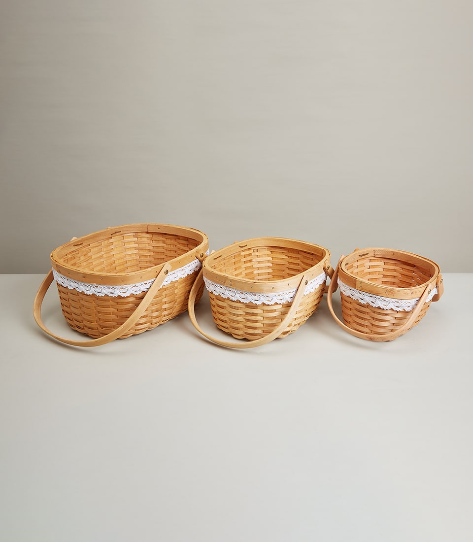 Nested woven wood baskets with white lace trim and curved handles, three sizes for elegant gift presentation