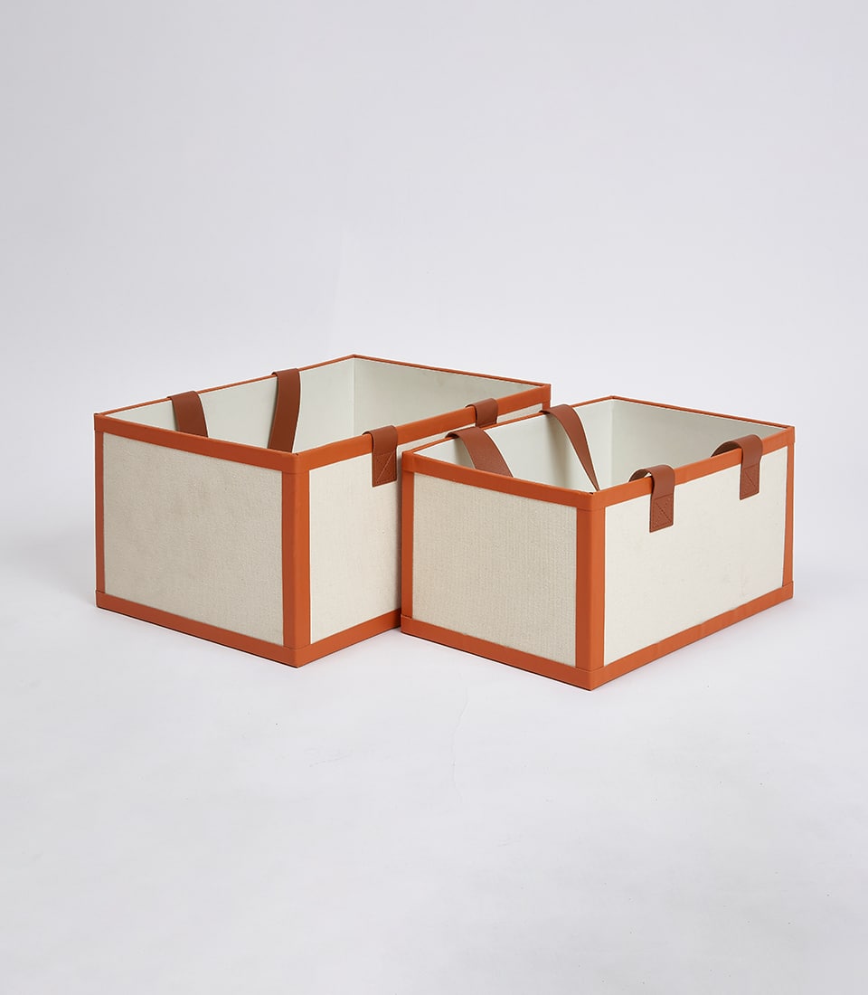 Cream fabric storage boxes with burnt orange trim and leather handles for luxury gift packaging
