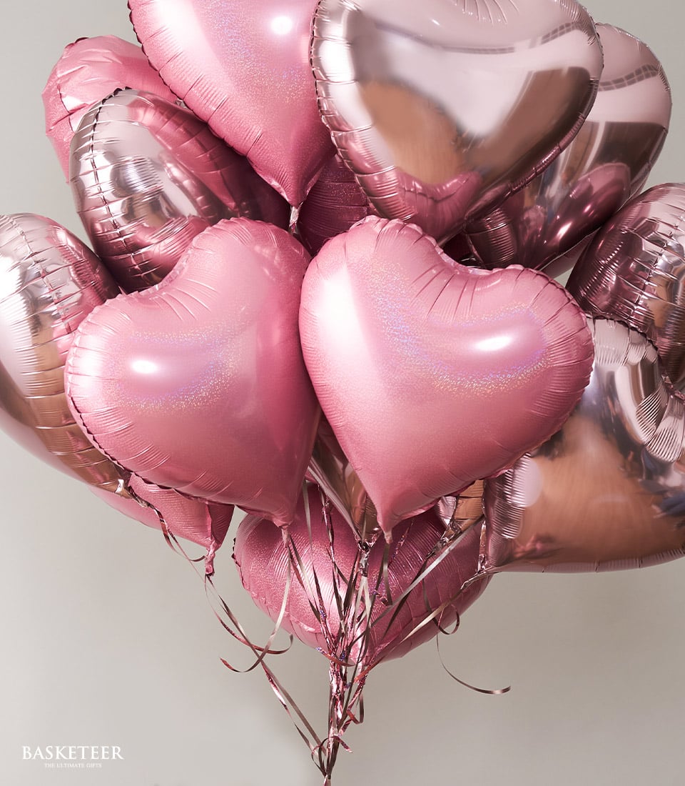 Pink and rose gold heart-shaped foil balloons in metallic and holographic finishes, arranged in a romantic birthday gift
