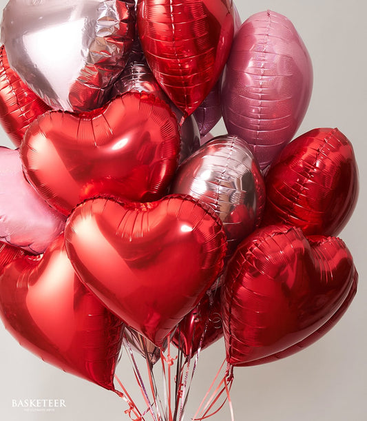 Red and pink foil heart balloons with metallic finish, tied with ribbons for gift-giving