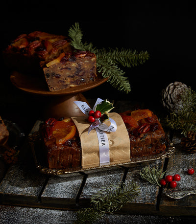Rich British fruitcake with candied citrus and pecans, festive Christmas gift hamper arrangement