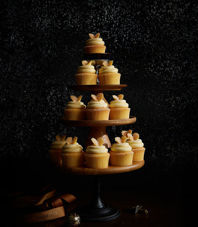 Vanilla buttercream cupcakes with candied ginger, tiered Christmas display on wooden stand