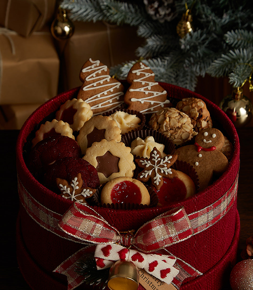Red Christmas cookie gift box with gingerbread men, iced trees, and festive shortbread assortment