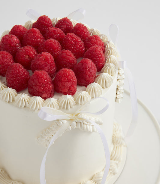 Raspberry Elegance white buttercream layer cake with fresh raspberries and white piping detail