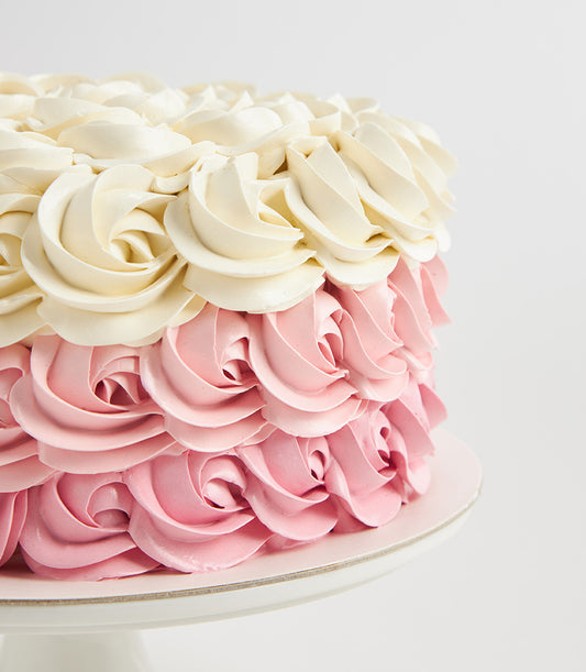 Charlotte Bakery custom cake Bangkok: Round artisan cake with strawberry pink and vanilla buttercream rosettes. Perfect for birthday cake delivery in Bangkok.