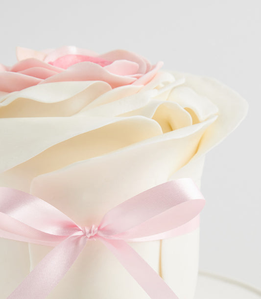 Pink fondant celebration cake with hand-crafted sugar rose bloom and ivory base