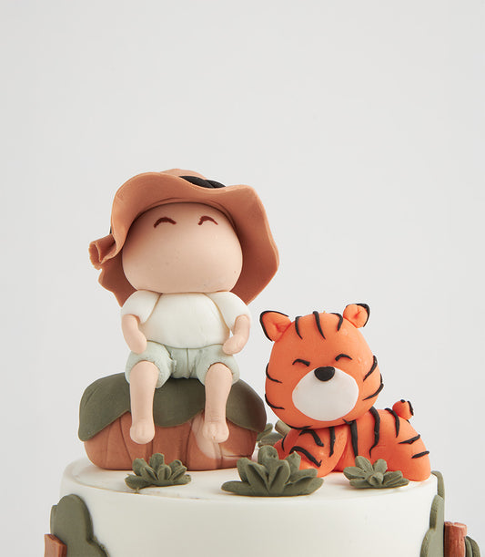 Custom jungle explorer cake with fondant adventurer and tiger cub for kids' birthdays