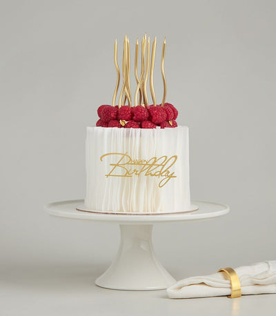 Raspberry crown white birthday cake with gold leaf, wafer candles, and happy birthday script