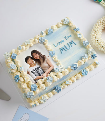 Personalised Mother's Day vanilla cake with edible photo, blue frosting, and edible flowers
