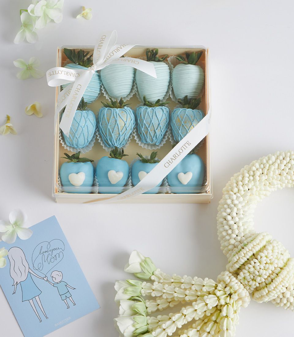 Light blue chocolate-covered strawberries with gold lattice details, greeting card, and white jasmine garland Mother's Day