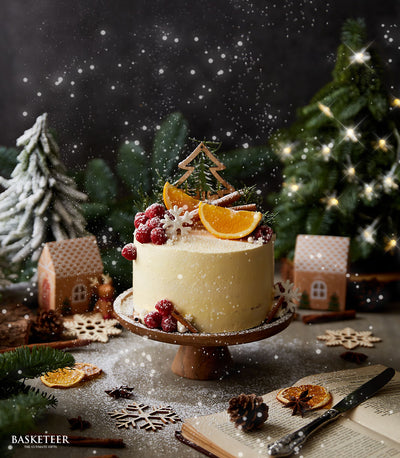 Winter Wonderland orange cake with raspberry, orange slice, and cinnamon stick toppings on festive holiday display