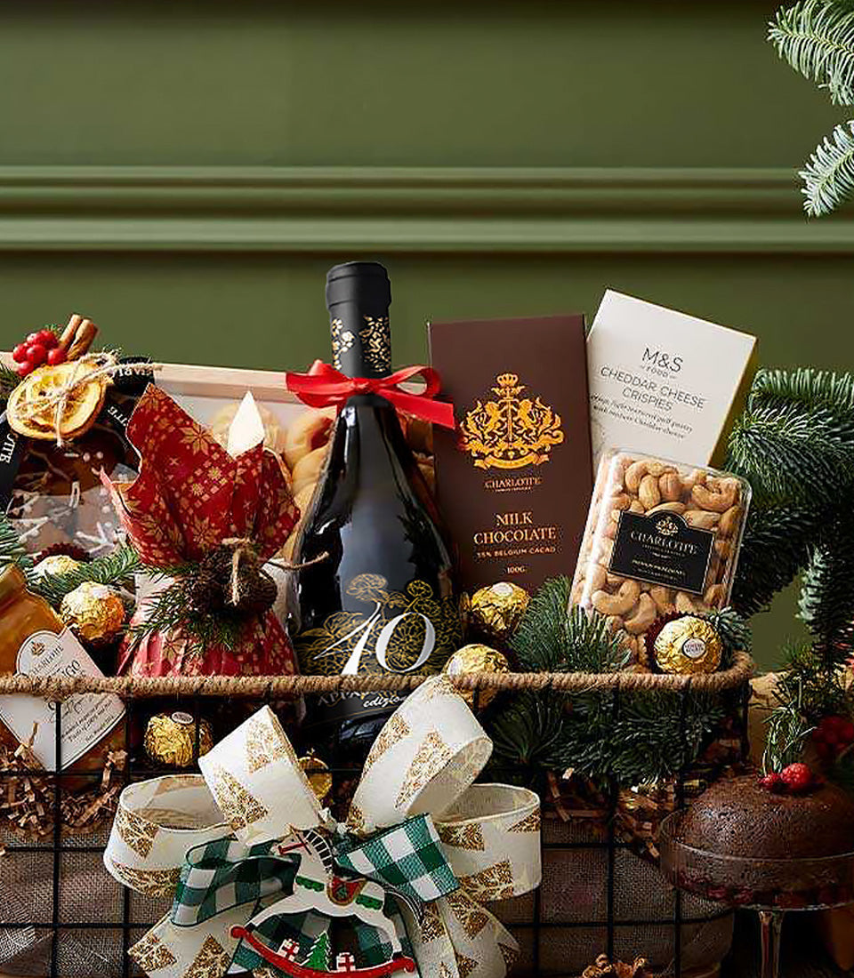 Festive red wine gift basket with gourmet chocolate, cheese crisps, cashews, and holiday garnish