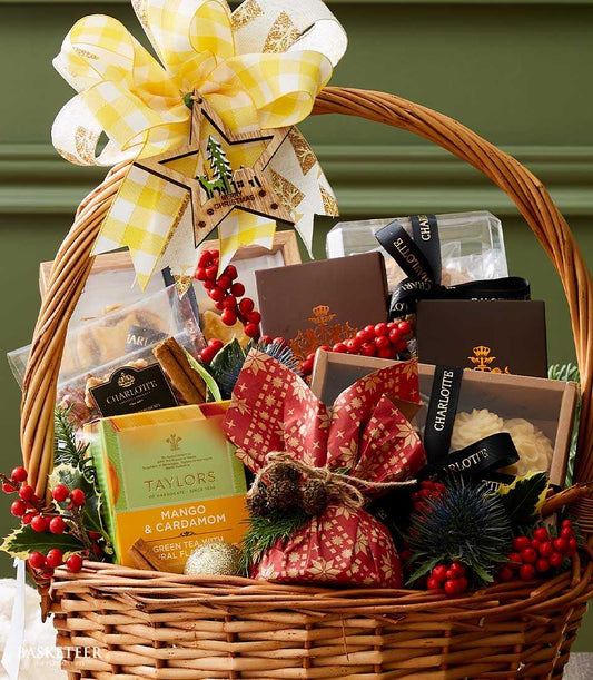 Premium Christmas hamper with gourmet sweets, specialty tea, and festive decorations in woven wicker basket