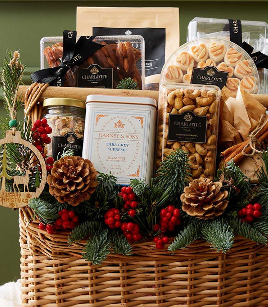 Luxury Christmas gift basket with gourmet treats, premium tea, and festive pine decorations in woven wicker