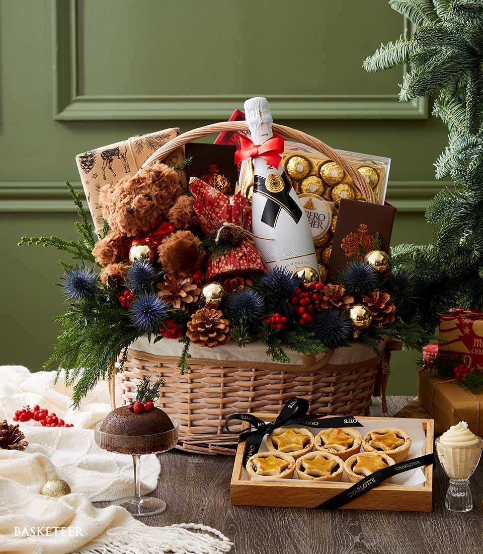 Woven wicker Christmas gift basket with Moët champagne, Ferrero Rocher chocolates, festive florals, and holiday ornaments
