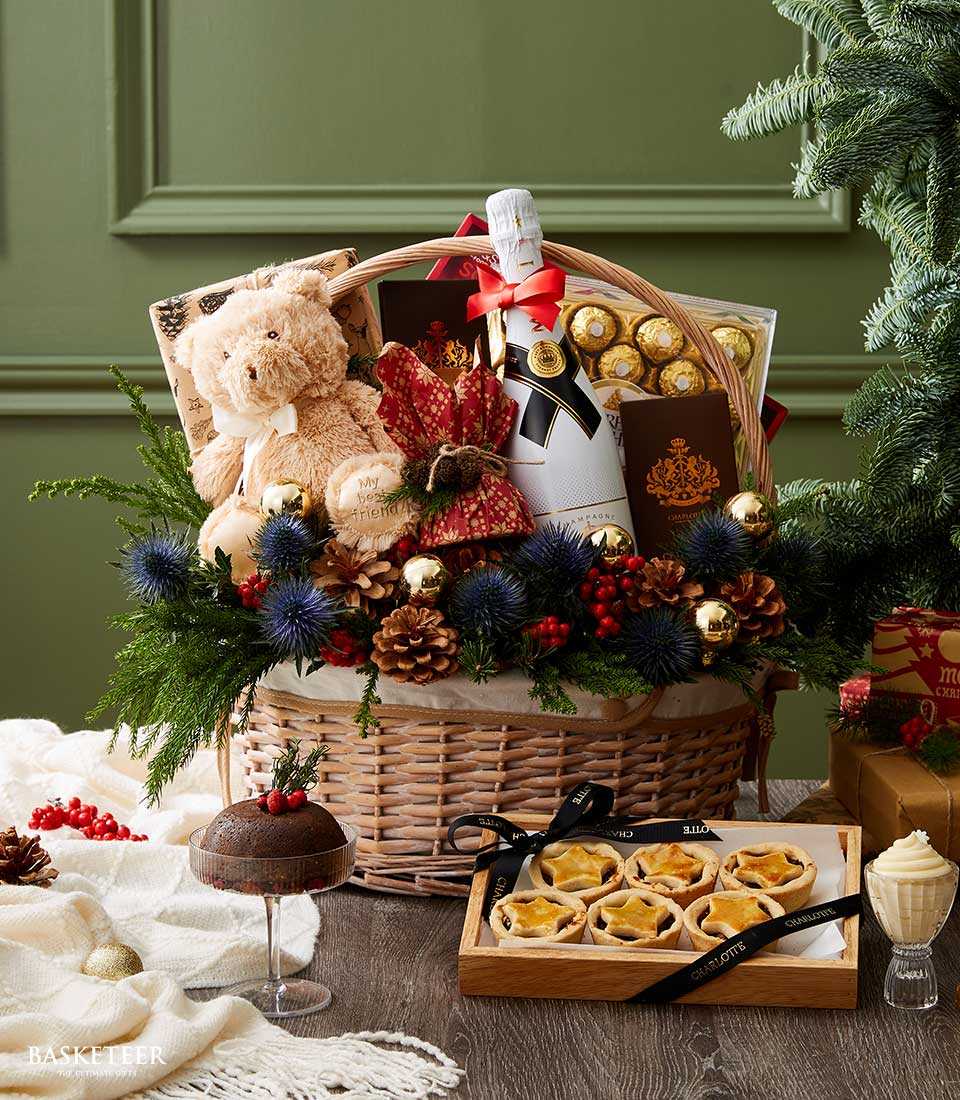 Luxury wicker Christmas gift basket with Moët champagne, teddy bear, Ferrero Rocher chocolates, and festive greenery