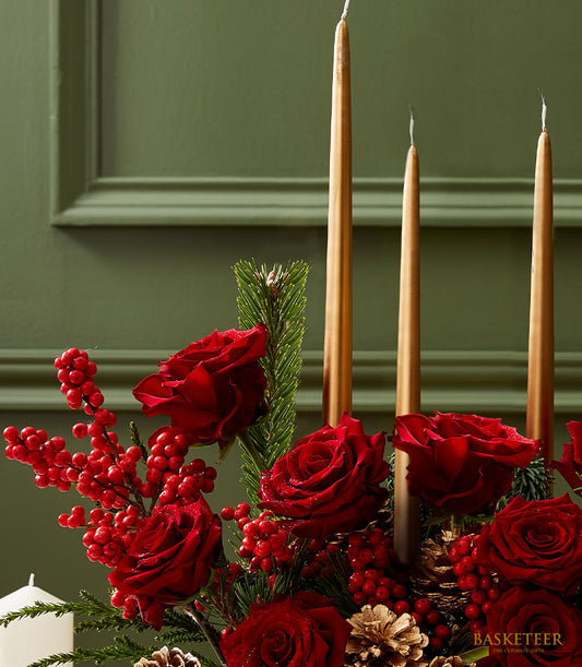 Festive red roses with gold taper candles, pine, and berries Christmas centerpiece gift