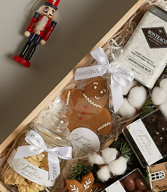 Winter wonderland gourmet gift box with gingerbread cookies, festive tea tin, chocolates, and wooden nutcracker